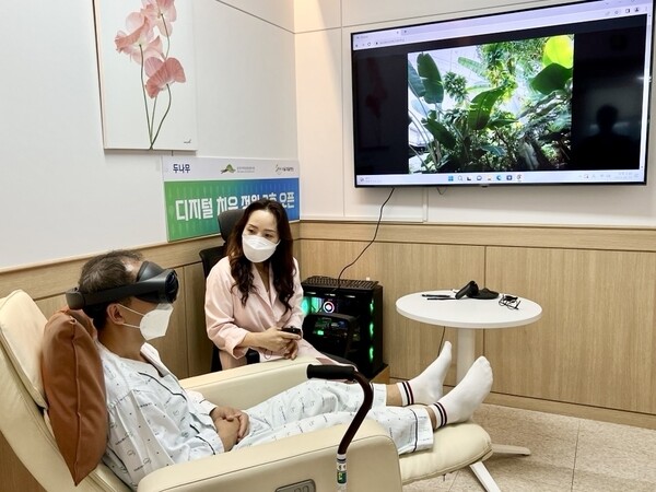 디지털 치유 정원 2호점이 설치된 '서울재활병원'에 입원 중인 환자가 국립세종수목원을 촬영한 VR 영상을 직접 체험하고 있다(제공=두나무)